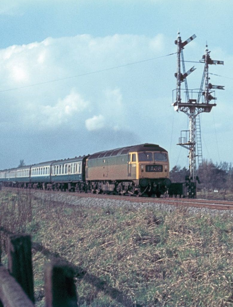 No April Fool, No. D1564 (later 47447) powers a mixed rake of blue and grey Mk.1 and Mk.2 coaches past a delightful semaphore signal at Babworth on the East Coast Main Line on April 1, 1970.