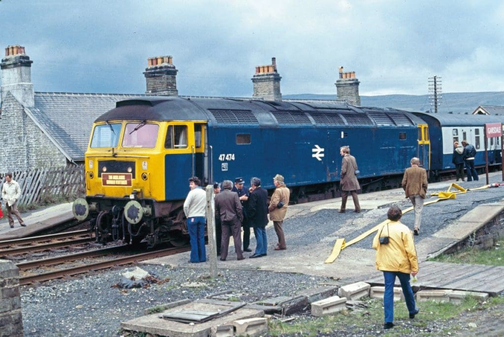 Some animated discussion appears to be taking place on the platform at Garsdale, where No. 47474 (originally 1602) in standard BR blue has paused with the ‘Midlands Border Venturer’ railtour on May 13, 1978.